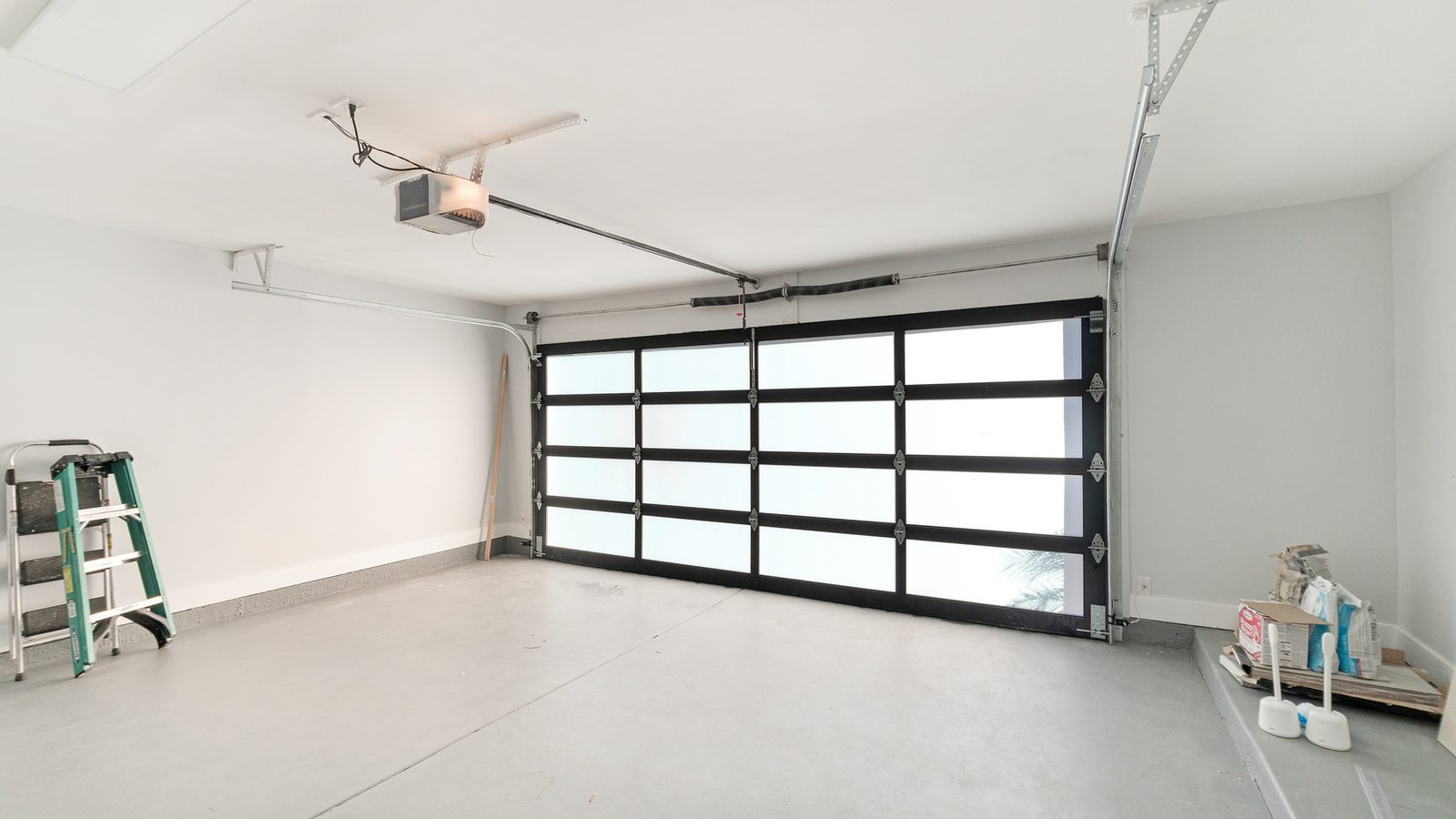 Clean white garage interior with glass panel door and opener